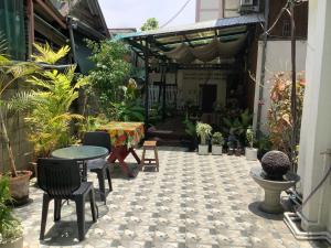 a courtyard with a table and chairs and plants at Tata GuestHouse in Chiang Mai