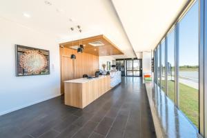 an office lobby with a reception desk and large windows at Pacific Sands Apartments Mackay in Mackay