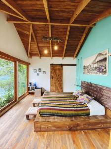 1 dormitorio con 1 cama grande y techo de madera en Baba Yaga Atitlan en San Marcos La Laguna