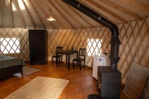 a room with a stove in a yurt with a table at Gala park fpv in Avren