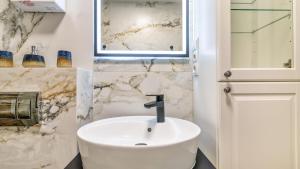 a bathroom with a white sink and a mirror at STEGNA PARK C Apartamenty Piamola WiFi in Stegna