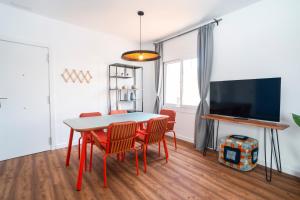 een eetkamer met een tafel en stoelen en een tv bij Caliu Apartments Barcelona in Hospitalet de Llobregat