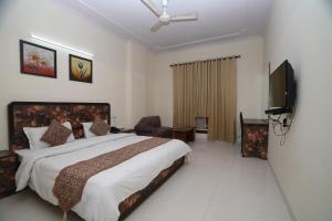 ニューデリーにあるHotel Silver Arc - Karol Bagh New Delhiのベッドルーム(大型ベッド1台、薄型テレビ付)