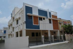 ein blau-weißes Gebäude mit einem Zaun in der Unterkunft Live Inn JP Nagar in Tiruchchirāppalli