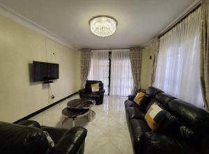 a living room with a leather couch and a table at K-Cube Villas in Kampala
