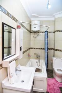 a bathroom with a white sink and a toilet at K-Cube Villas in Kampala