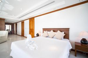 1 dormitorio con cama blanca y sofá en Patongtower Duplex Seaview4BR2902, en Patong Beach