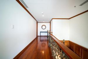 um corredor com paredes brancas e uma escada de madeira em Patongtower Duplex Seaview4BR2902 em Patong Beach