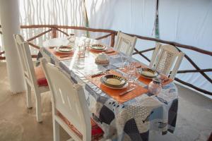 a dining room table with chairs and a tablecloth on it at Cosy Cottage Marine Park - 2 Rooms in Malindi