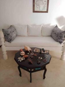 a living room with a white couch and a coffee table at Cosy Cottage Marine Park - 2 Rooms in Malindi