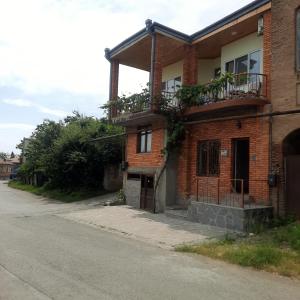 a brick house with two balconies on a street at Luca Lili in Sighnaghi