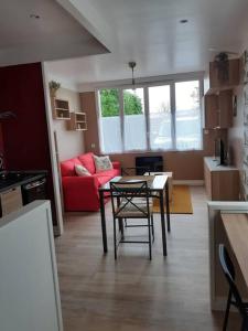 een woonkamer met een tafel en een rode bank bij Mini Loft in Saintes