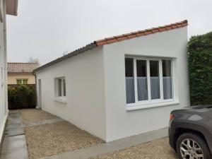 a white house with a car parked in front of it at Mini Loft in Saintes +3 photos