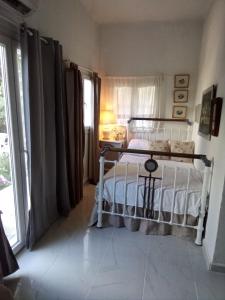 a bedroom with a white bed and a window at Marathon agios panteleimon attiki Greece in Panayía Mesosporítissa