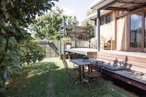 Un patio con una mesa y sillas en un patio. en Back Beach Villa, en Woolgoolga