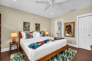 a bedroom with a large bed and a ceiling fan at Vibrant Pool Home! Kayak, Firepit & Playground! in West Palm Beach +78 photos