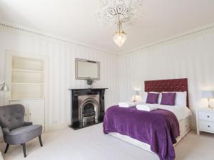 Un dormitorio con una cama, una silla y una lámpara de araña. en Mary Ann Villa, en Inverness