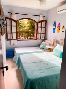 Giường trong phòng chung tại Recantos Pinheiros - Casa inteira, até 10 pessoas - Piscina, área verde, sinuca, e ar condicionado - Condomínio Orla 500 - Unamar, Cabo Frio