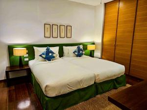 una camera da letto con un grande letto con cuscini blu di Beachfront 2 BR Luxury Apartment Chava Surin a Surin Beach