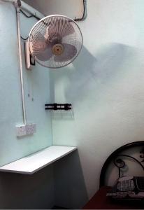 a room with a fan on the wall at Langkawi-Village Mix Dormitory in Pantai Cenang