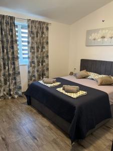 een slaapkamer met 2 bedden en een raam bij Pula Apartment E&E in Loborika