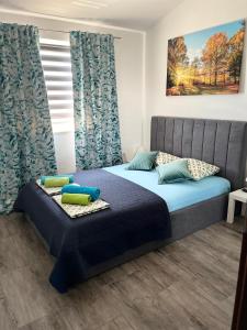 a bedroom with a bed with blue sheets and pillows at Pula Apartment E&E in Loborika