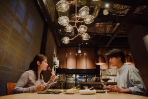 un hombre y una mujer sentados en una mesa en un restaurante en Aloft Osaka Dojima en Osaka