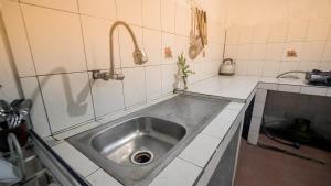 cocina con encimera con fregadero de acero inoxidable en Rumah Gaharu - Kamar Kulon, en Bedoyo