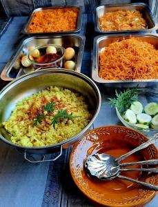 una mesa cubierta con bandejas de diferentes tipos de alimentos en Rumah Nalu surf camp, en Krui