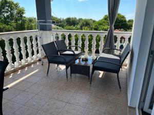 een patio met stoelen en een tafel op een balkon bij Pula Apartment E&E in Loborika