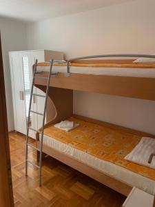 two bunk beds in a room with a ladder at Aurora in Pag