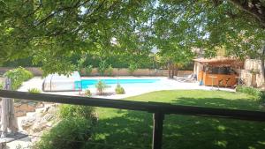 a backyard with a swimming pool and a fence at Les dodos de Rose in Doué-la-Fontaine