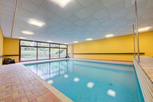 a swimming pool with blue water in a room with yellow walls at Residenza Borgo Rustico with Pool - Happy Rentals in Collina d'Oro