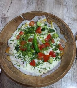une pizza avec des légumes sur une assiette dans l'établissement Апартамент в центре города Худжанд, à Khodjent
