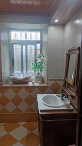un bagno con lavandino, specchio e finestra di CASA BERELY a Cariño