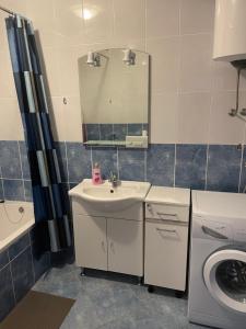 a bathroom with a sink and a mirror and a washing machine at Aurora in Pag +28 photos