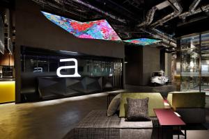 a living room with a couch and a sign at Aloft by Marriott Osaka Umeda in Osaka