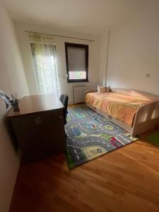 ein Schlafzimmer mit einem Bett und einem Teppich auf dem Boden in der Unterkunft Center flat in Skopje
