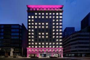 a tall building with pink lights on it at Aloft by Marriott Osaka Umeda in Osaka