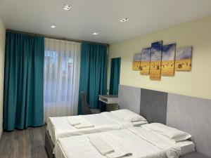 a hotel room with two beds and blue curtains at Kapriz Issyk Kul Resort in Cholpon-Ata
