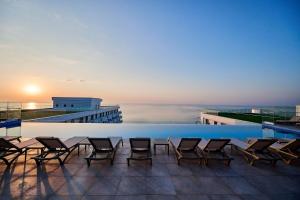 a pool on the roof of a building with chairs at Tropical Apartament - Spa&Pool in Infinity Beach Resort in Mamaia
