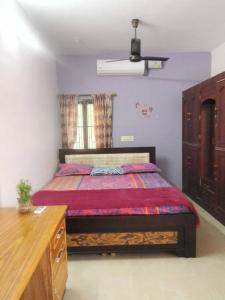 a bedroom with a bed and a wooden dresser at Aathira's 2 Bedroom house @ Heart of Coimbatore in Coimbatore