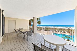 a balcony with a table and chairs and the beach at White Caps 204 in Orange Beach