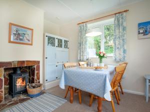 a dining room with a table and a fireplace at Sweets Close in St Austell