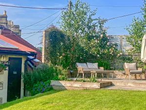 a garden with two chairs and a bench in a yard at The Stable in Camerton