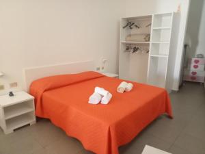 ein Schlafzimmer mit einem orangenen Bett mit Handtüchern darauf in der Unterkunft Cala Maluk in Lampedusa