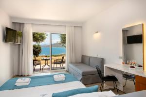 a hotel room with a bed and a view of the ocean at Balos Beach in Kissamos