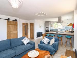 a living room with a blue couch and a kitchen at The Stables in Newport