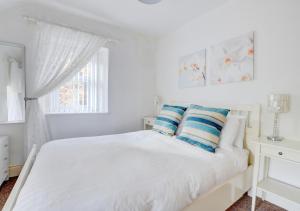 ベトウス・ア・コーエドにあるManarosの白いベッドルーム(青と白の枕が付くベッド付)