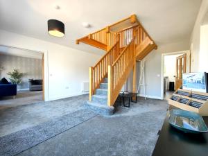 a living room with a wooden staircase in a house at Sanderson House in Cleator Moor